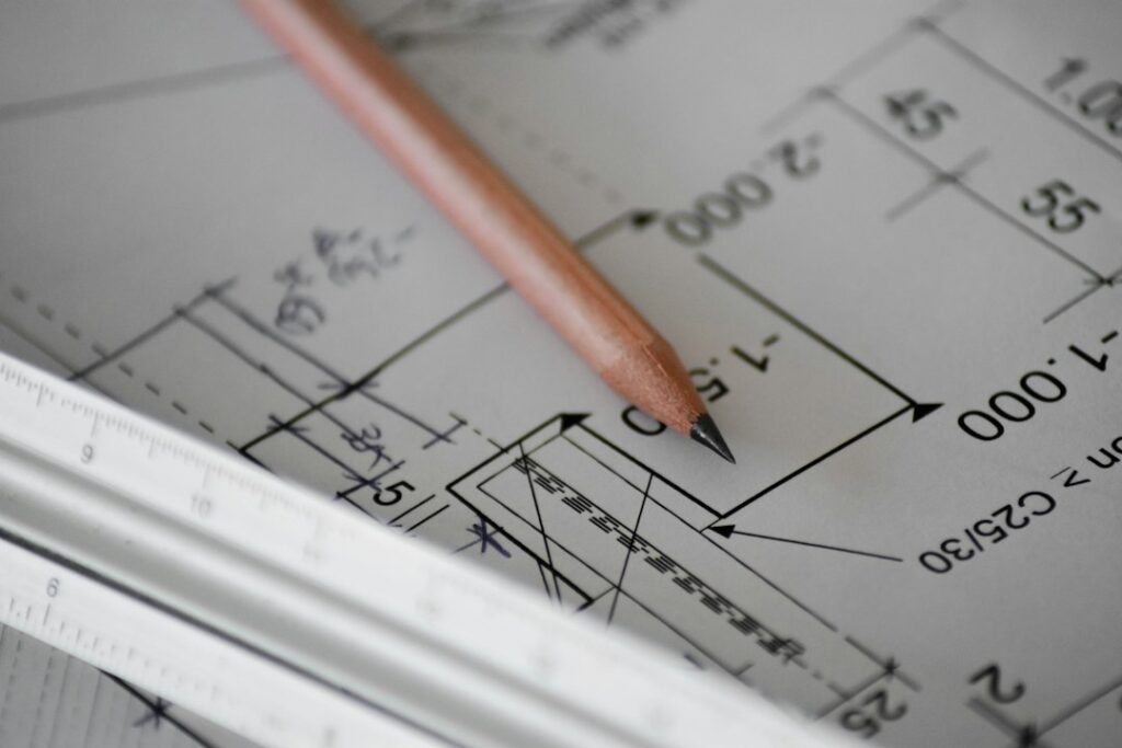Planos técnicos y cálculos sobre una mesa de trabajo: estudios de prefactibilidad y factibilidad